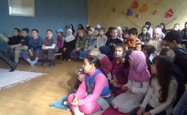 Kinder sitzen am Boden im Kindergarten