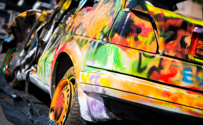 Bild zeigt ein mit Graffiti besprühtes Auto 